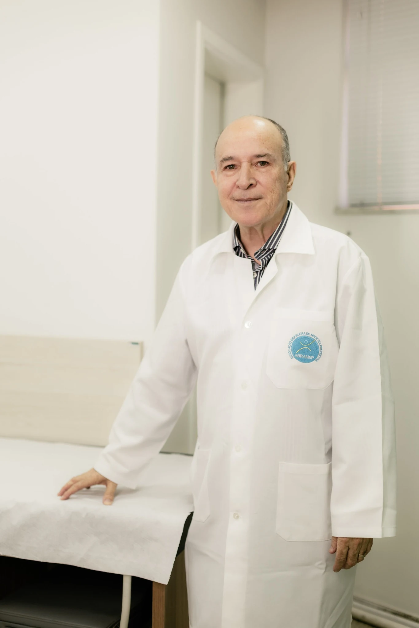 Dr. Adilson Rosa de jaleco no consultório